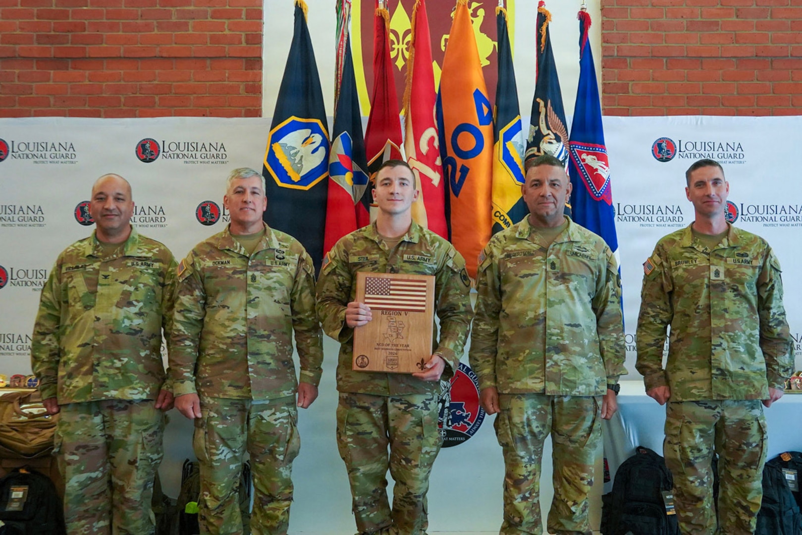 Staff Sgt. Elija Steil, assigned to Bravo Company, 39th Brigade Support Battalion, 39th Infantry Brigade Combat Team, Arkansas Army National Guard, poses with senior Louisiana National Guard leaders after being named Region V Noncommissioned Officer of the Year during the Region V Best Warrior Competition awards ceremony at Jackson Barracks in New Orleans, Louisiana, May 7, 2026.