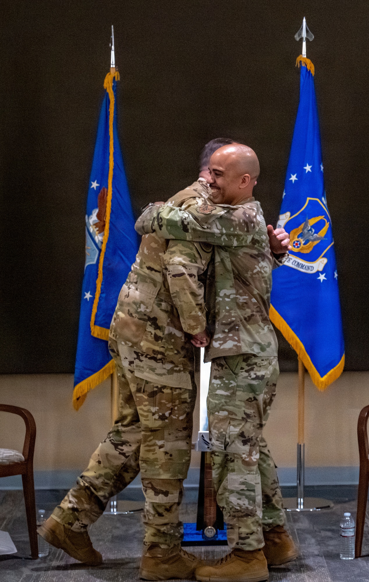 Two Airmen hug during a ceremony