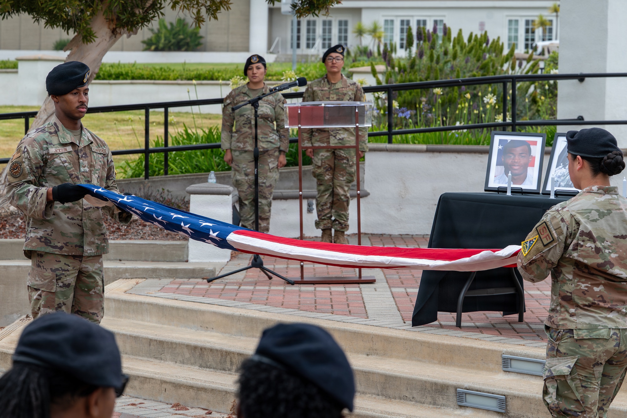 Two people hold a stretched-out American flag.