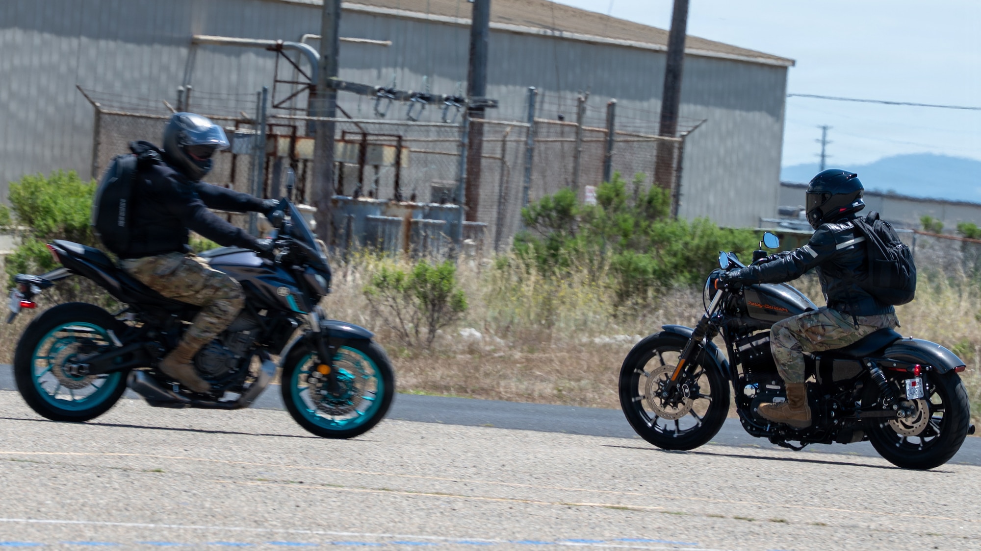 Two motorcycles drive past each other as they turn opposite ways