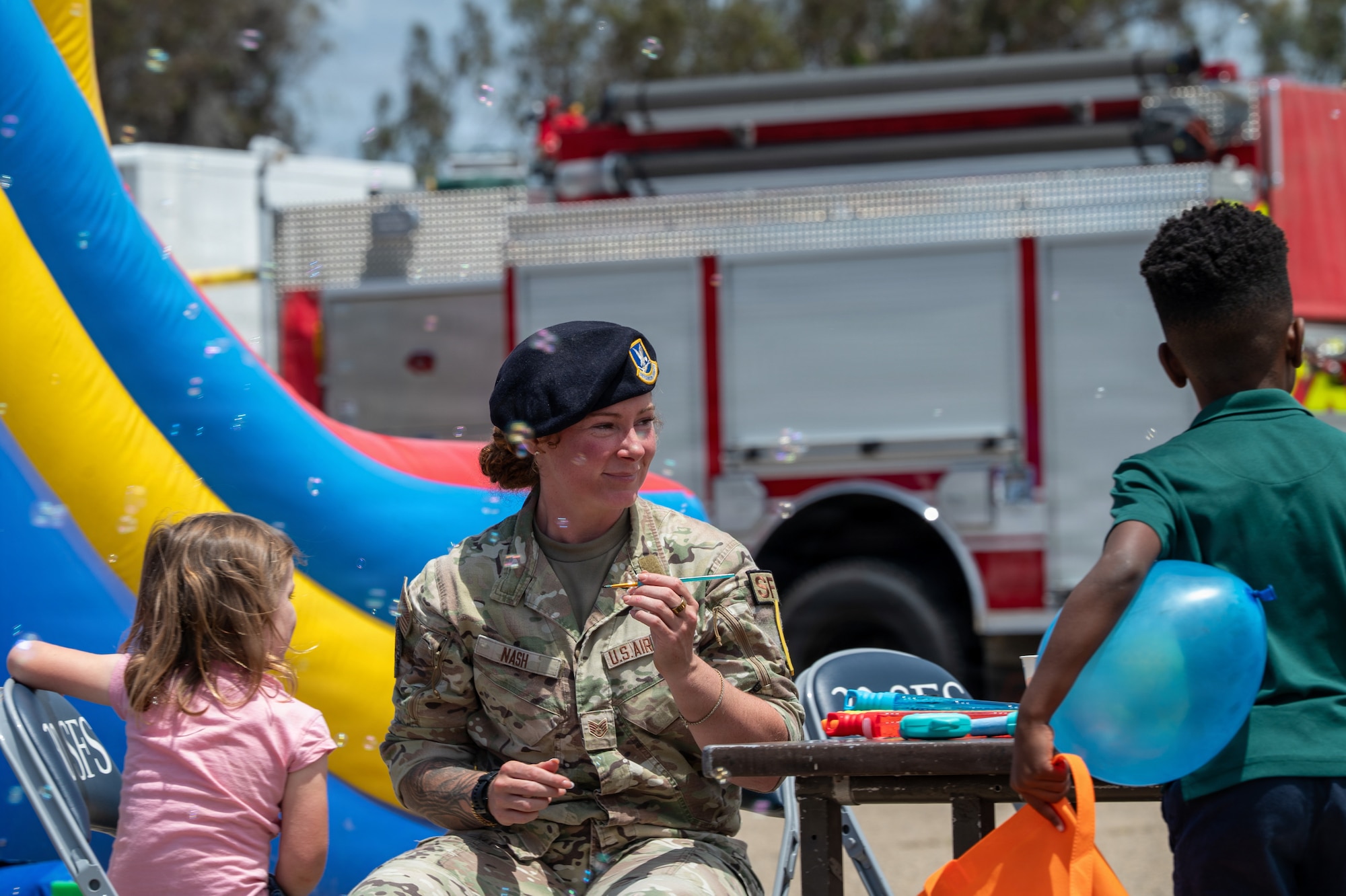 U.S. Air Force Staff Sgt. Cortlynn Nash sits down and holds a face-painting brush outside.