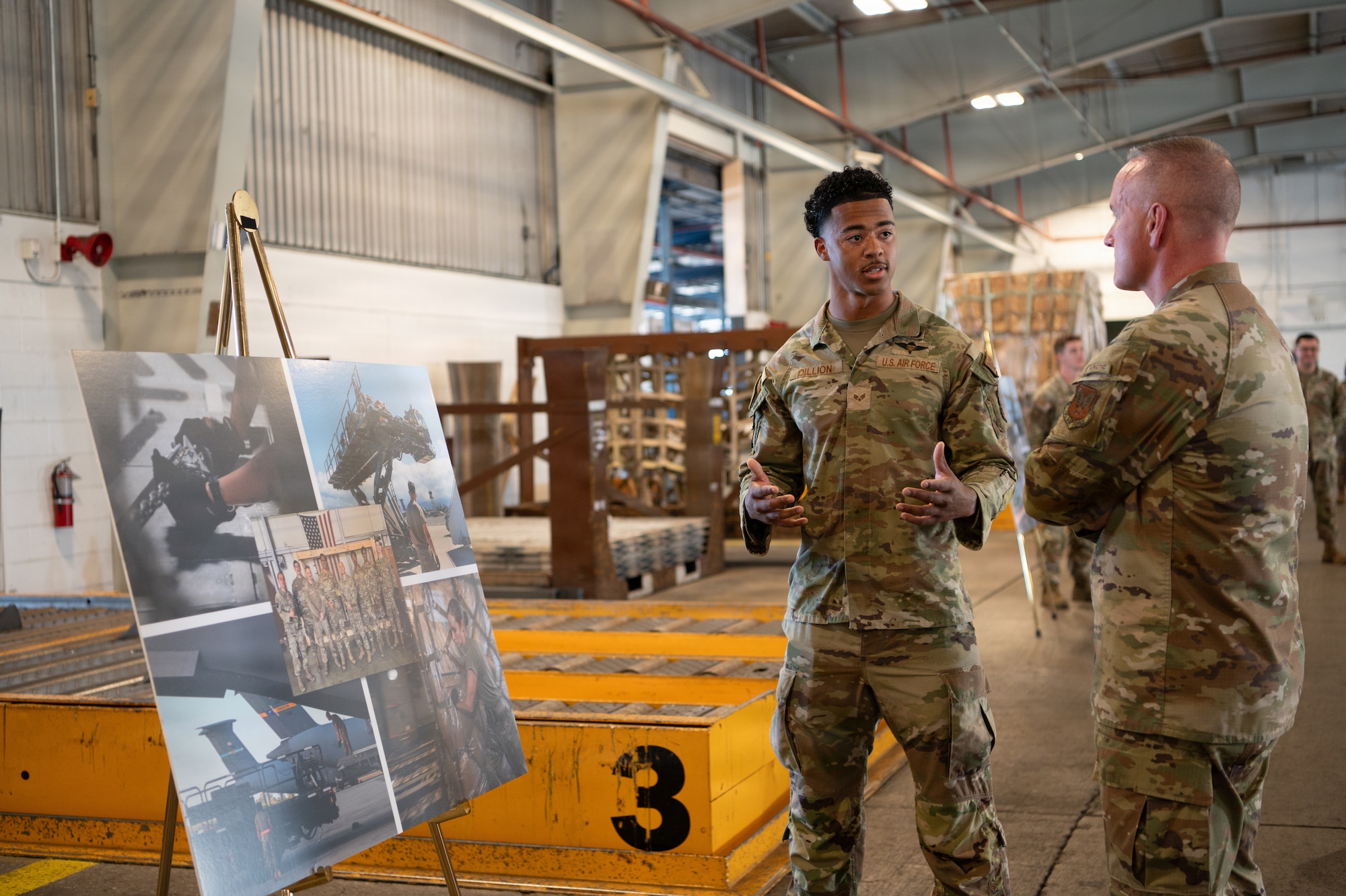 Chief Master Sergeant of the Air Force David Wolfe listens to a briefing presented by Senior Airman Izaiah Dillion.