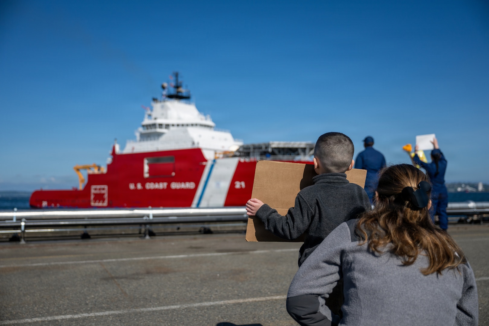 A family watches U.S. Coast Guard Cutter Storis (WAGB 21) return to Coast Guard Base Seattle following a 36-day patrol to the Bering Sea, May 11, 2026. Storis is a 360-foot medium icebreaker capable of navigating through three feet of ice at five knots, adding crucial capabilities to the Coast Guard's Arctic operations. (U.S. Coast Guard photo by Petty Officer 2nd Class Briana Carter)