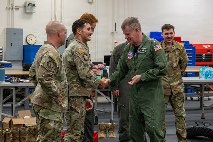 Adm. Samuel J. Paparo, commander of U.S. Indo-Pacific Command, coins Tech. Sgt. Ahron Rasabi, 15th Operational Support Squadron Survival, Evasion, Resistance and Escape (SERE) Specialist at Joint Base Pearl Harbor-Hickam, May 13, 2026. Rasabi assisted during a SERE instructional course, demonstrating hand-to-hand combat fundamentals and proper techniques. (U.S. Air Force photo by Senior Airman Lauren Torres)