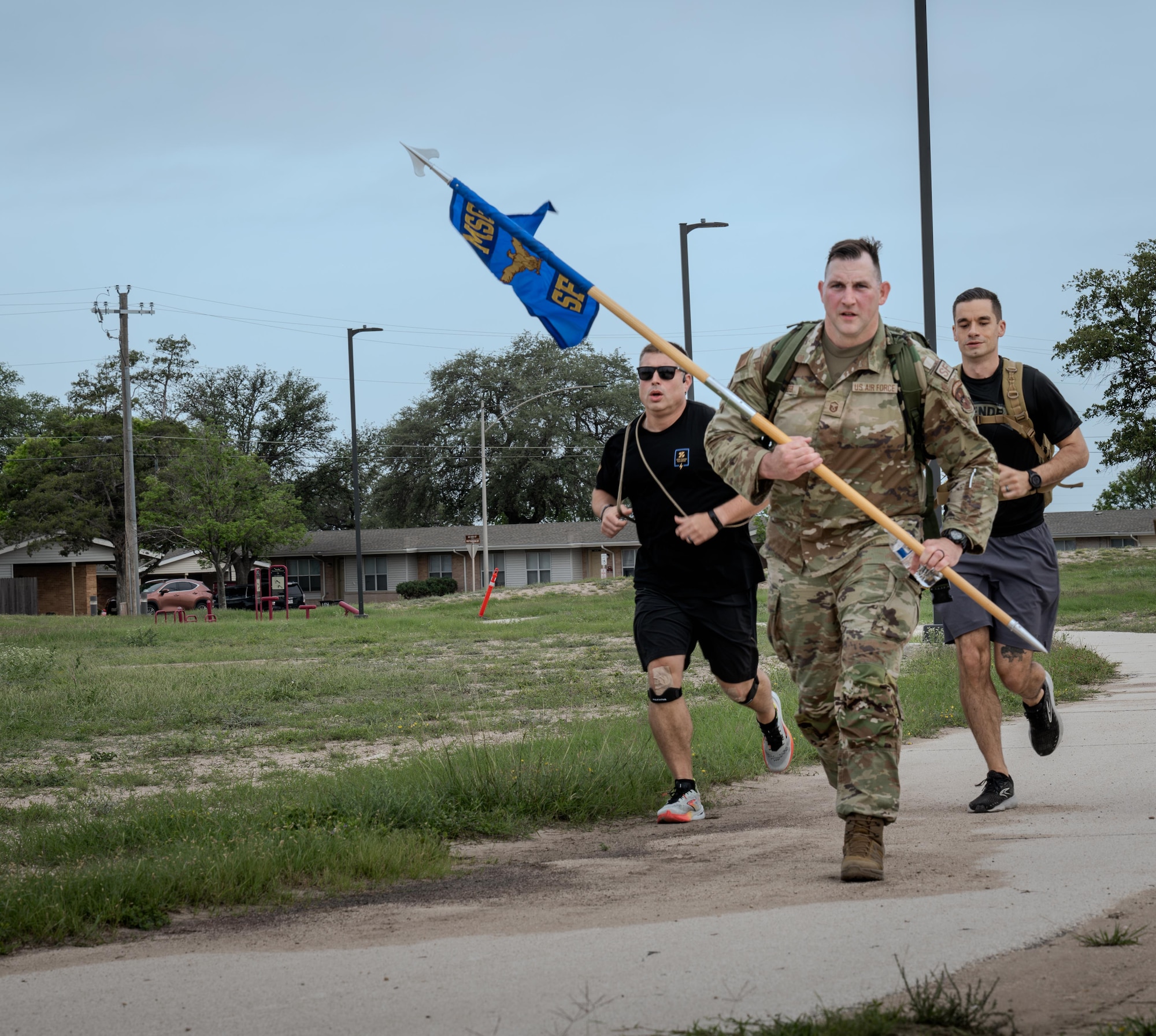 U.S. Air Force Master Sgt. William Slifer, 47th Security Force Squadron, acting first sergeant, carries the 47th SFS guidon to lead the police week 5k ruck march at Laughlin Air Force Base, Texas, May 4, 2026. Airmen took part in a 5K ruck march in remembrance of those who have served in the line of duty. (U.S. Air Force photo by Airman 1st Class Harrison Sullivan)