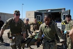 Hospital Corpsman 2nd Class Nya Jobs (right), respiratory therapist, Lt. j.g. Mark Gregg (left), trauma nurse, Capt. David Samaha (middle), general surgeon, and Lt. j.g. Melissa Sullivant (back), trauma nurse, all assigned to Navy Medicine Readiness and Training Command (NMRTC) Jacksonville, transport a casualty from an ambulance into their mission support site during an Expeditionary Resuscitative Surgical System (ERSS) course conducted by Naval Expeditionary Medicine Warfighter Development Center (NEMWDC) Oct. 21, 2025. Despite being brought together shortly before the drill, the group maintained clear communication and coordinated movement throughout the scenario. (U.S. Navy photo by Petty Officer 2nd Class Kwame Obengyeboah)