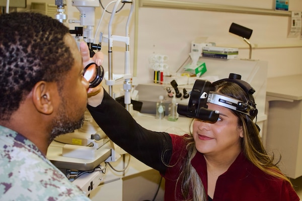 Catherine Ortiz (right), a Doctor of Optometry student from Western University of Health Sciences, conducts an eye examination with Hospital Corpsman 2nd Class Emilio Matthew at Naval Hospital Twentynine Palms in April 2026. Ortiz completed a clinical rotation at the hospital as part of a partnership that provides optometry students with hands-on experience in a military healthcare environment. (U.S. Navy photo by Hospital Apprentice Evelyn Zermeno)