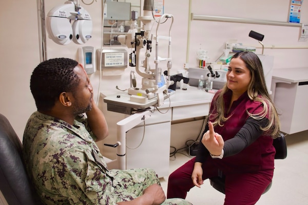 Catherine Ortiz (right), a Doctor of Optometry student from Western University of Health Sciences, conducts an eye examination with Hospital Corpsman 2nd Class Emilio Matthew at Naval Hospital Twentynine Palms in April 2026. Ortiz completed a clinical rotation at the hospital as part of a partnership that provides optometry students with hands-on experience in a military healthcare environment. (U.S. Navy photo by Hospital Apprentice Evelyn Zermeno)