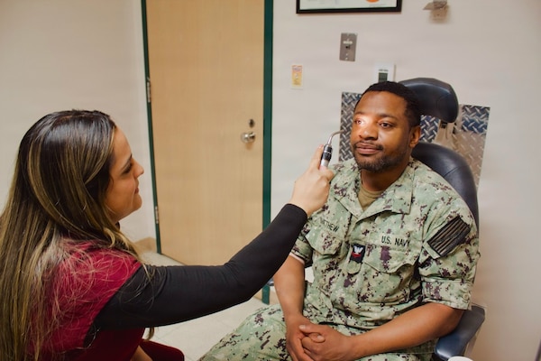 Catherine Ortiz (left), a Doctor of Optometry student from Western University of Health Sciences, conducts an eye examination with Hospital Corpsman 2nd Class Emilio Matthew at Naval Hospital Twentynine Palms in April 2026. Ortiz completed a clinical rotation at the hospital as part of a partnership that provides optometry students with hands-on experience in a military healthcare environment. (U.S. Navy photo by Hospital Apprentice Evelyn Zermeno)