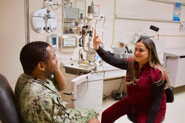 Catherine Ortiz (right), a Doctor of Optometry student from Western University of Health Sciences, conducts an eye examination with Hospital Corpsman 2nd Class Emilio Matthew at Naval Hospital Twentynine Palms in April 2026. Ortiz completed a clinical rotation at the hospital as part of a partnership that provides optometry students with hands-on experience in a military healthcare environment. (U.S. Navy photo by Hospital Apprentice Evelyn Zermeno)