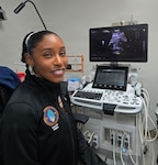Hospital Corpsman 2nd Class Arlesha Cooper-Revish poses for a photo in front of an ultrasound machine at U.S. Naval Hospital Guam. Cooper-Revish participated in hands-on training for advanced ultrasound techniques and maternal-fetal assessment skills to enhance skill development, strengthening both technical proficiency and clinical decision-making. (U.S. Navy photo by Hospital Corpsman 3rd Class Ashli Heaton)