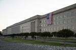 An American flag unfurls down the side of the Pentagon to celebrate Armed Forces Day and honor America's 250th birthday, May 16, 2026. The Betsy Ross flag features 13 white stars in a circle on a blue field with 13 alternating red and white stripes, symbolizing the original colonies.