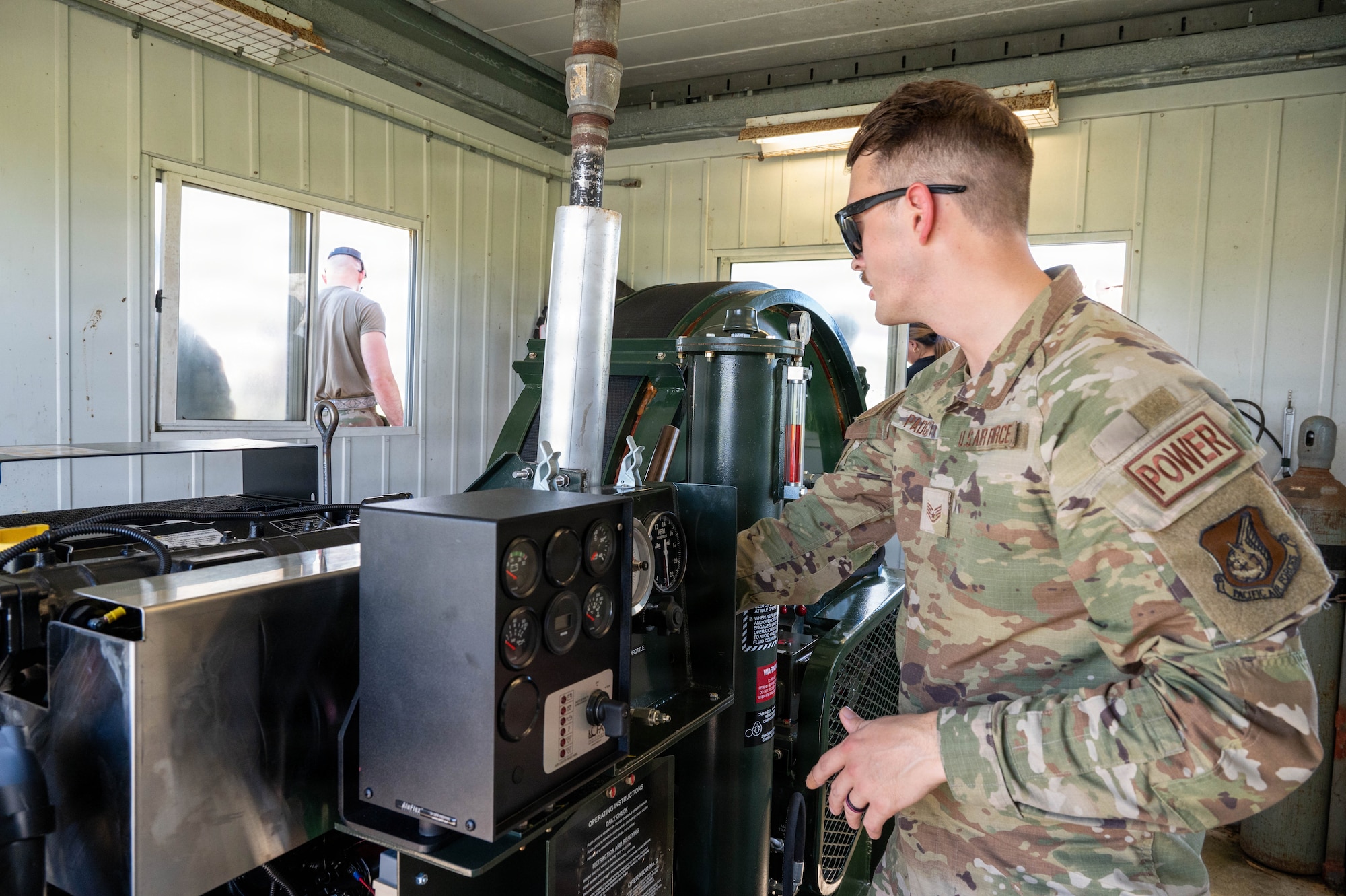Service member looking over machinery.