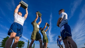 U.S. service members lift ammunition cans during the Warrior Gauntlet at Kadena Air Base, Japan, May 8, 2026. The event tested strength, endurance and resilience through challenges inspired by each branch’s physical fitness standards. (U.S. Air Force photo by Airman 1st Class Francisco Huerta)