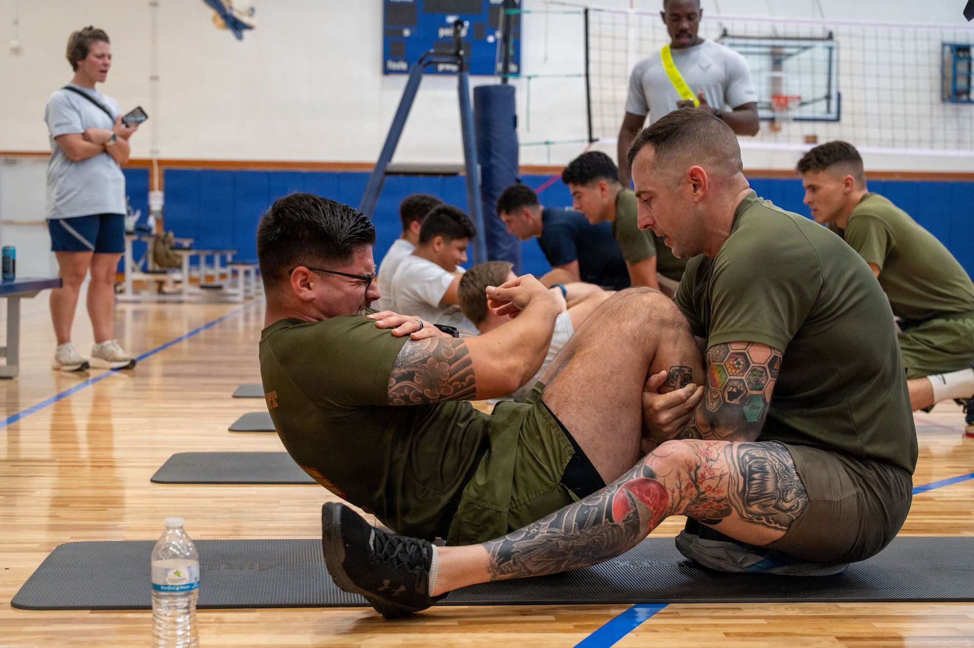 U.S. service members perform sit-ups during the Warrior Gauntlet at Kadena Air Base, Japan, May 8, 2026. The gauntlet pushed service members beyond their own branch's fitness benchmarks and exposed them to the physical requirements of their counterparts. (U.S. Air Force photo by Senior Airman Greydon Furstenau)