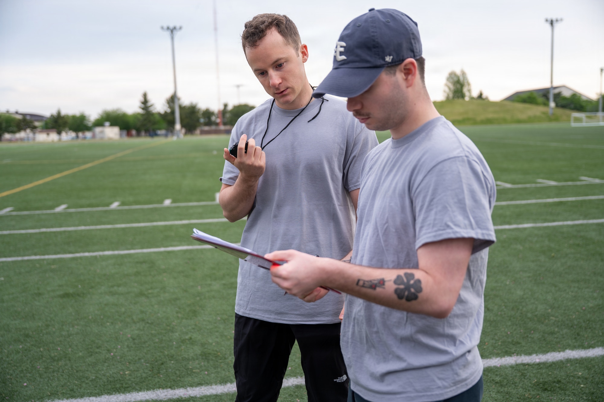 U.S. Air Force 1st Lt. Jackson Disilvestre, left, 13th Fighter Squadron chief of intelligence, and Senior Airman Robert Marts, 35th Force Support Squadron food service shift leader, record participant run times during a running clinic.