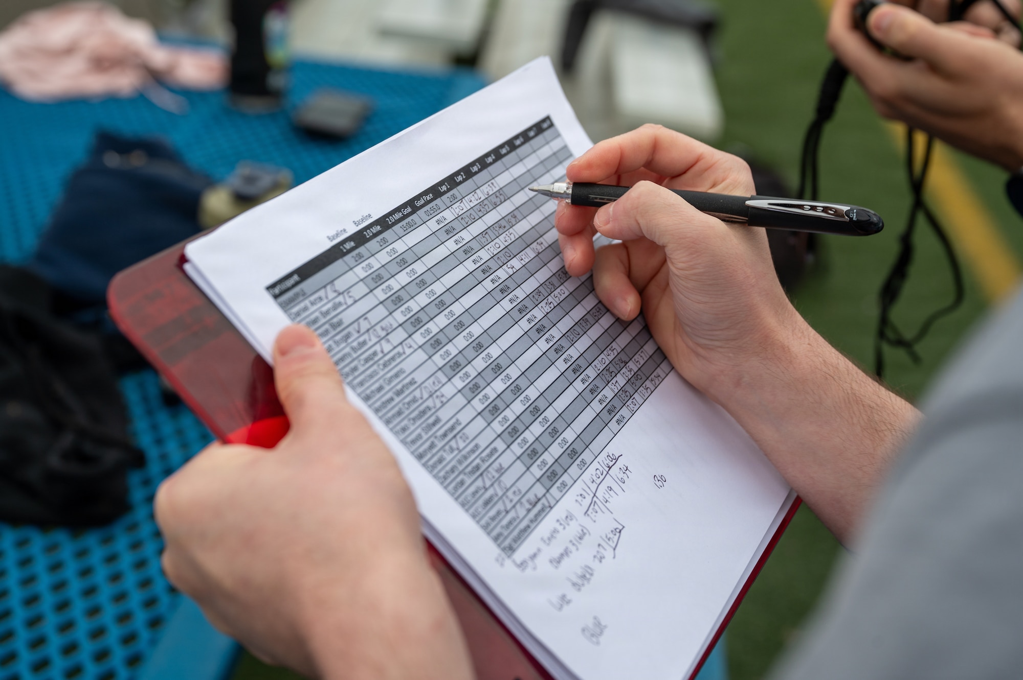 U.S. Air Force Senior Airman Robert Marts, 35th Force Support Squadron food service shift leader, records participant run times during a running clinic.