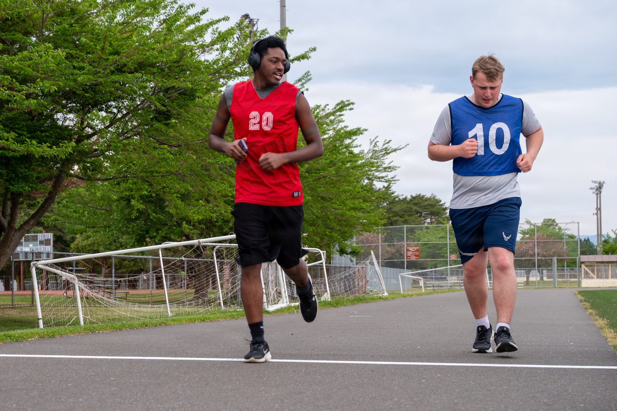 U.S. Air Force Staff Sgt. Donald Tull, left, 35th Munitions Squadron conventional maintenance technician support supervisor, runs alongside Airman 1st Class Henry Lokken, 35th Munitions Squadron conventional maintenance technician, during a running clinic.