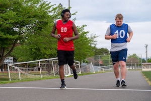 U.S. Air Force Staff Sgt. Donald Tull, left, 35th Munitions Squadron conventional maintenance technician support supervisor, runs alongside Airman 1st Class Henry Lokken, 35th Munitions Squadron conventional maintenance technician, during a running clinic.