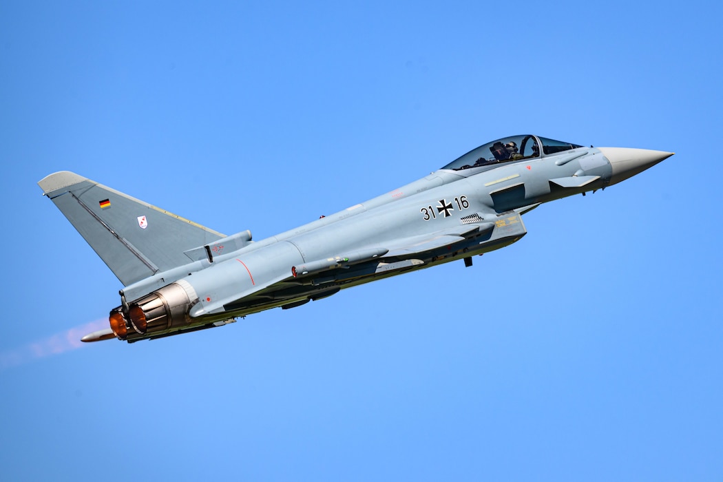 A fighter aircraft takes off using afterburners.