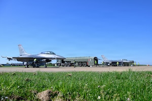 Two aircraft are refueled on a flightline at an air base.