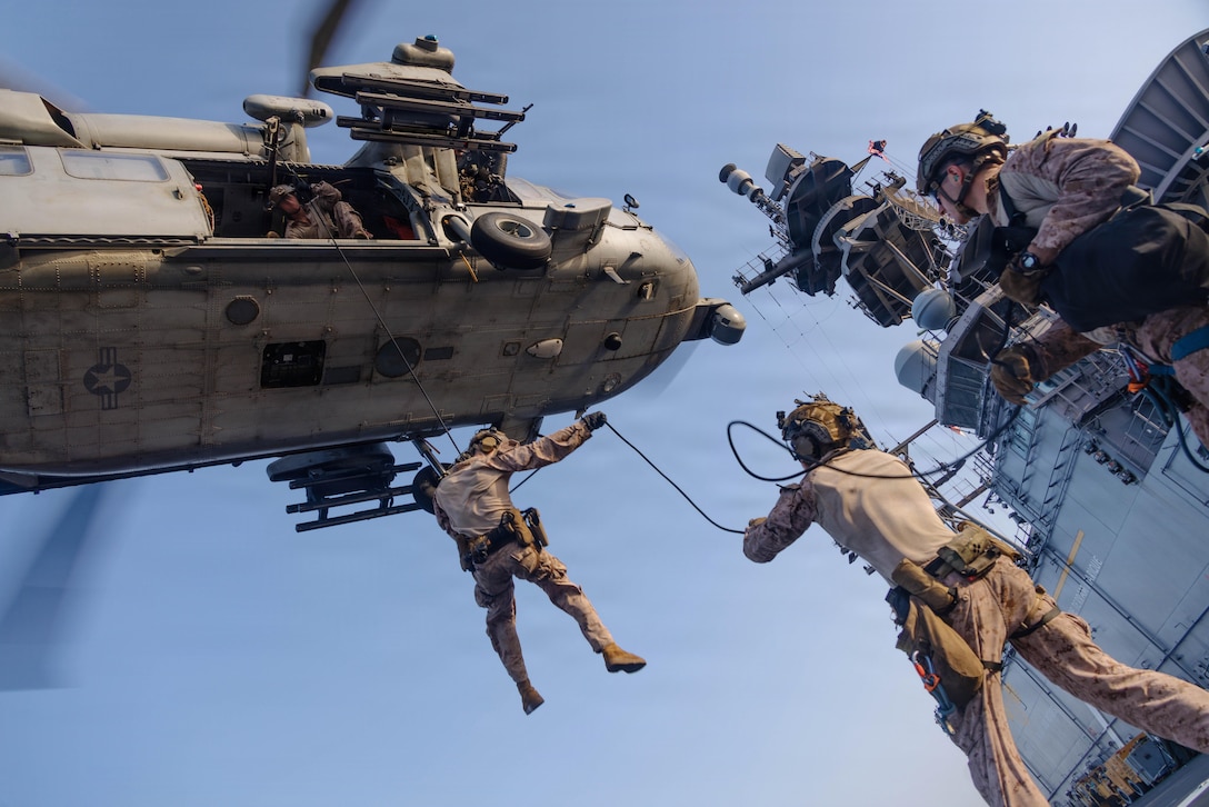 U.S. Marines with Maritime Raid Force, 31st Marine Expeditionary Unit, rappel out of an MH-60S Sea Hawk, assigned to Helicopter Sea Combat (HSC) Squadron 25, during helicopter and roping sustainment training aboard the forward-deployed amphibious assault ship USS Tripoli (LHA 7) in the U.S. Central Command area of responsibility, May 8, 2026. Tripoli is deployed to the U.S. 5th Fleet area of operations to support maritime security and stability in the Middle East. (U.S. Marine Corps photo)