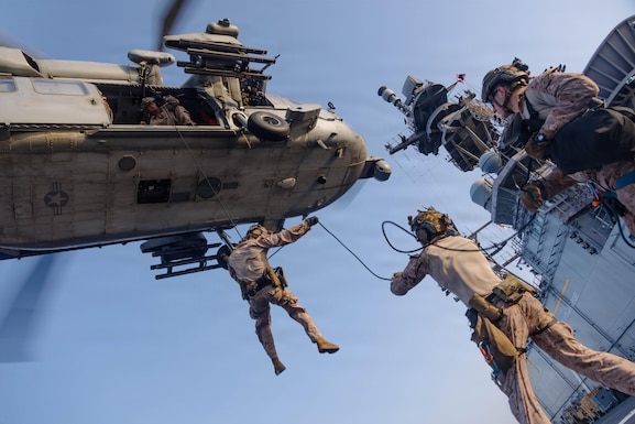 U.S. Marines with Maritime Raid Force, 31st Marine Expeditionary Unit, rappel out of an MH-60S Sea Hawk, assigned to Helicopter Sea Combat (HSC) Squadron 25, during helicopter and roping sustainment training aboard the forward-deployed amphibious assault ship USS Tripoli (LHA 7) in the U.S. Central Command area of responsibility, May 8, 2026. Tripoli is deployed to the U.S. 5th Fleet area of operations to support maritime security and stability in the Middle East. (U.S. Marine Corps photo)