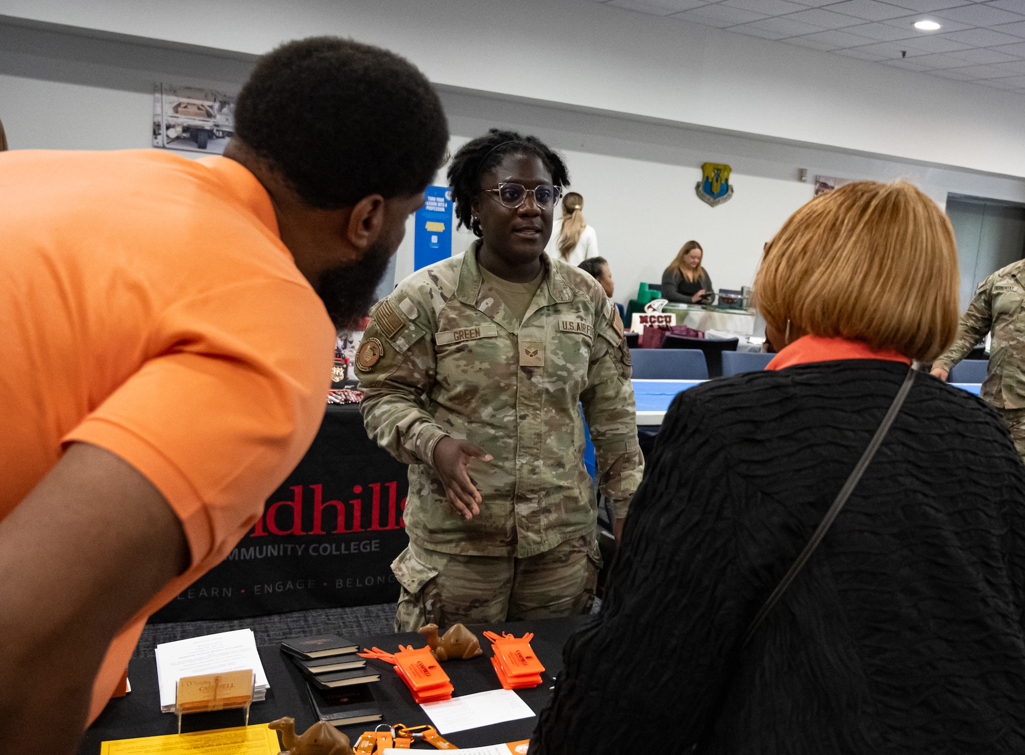 An Airman speaks with people.