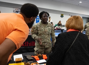 An Airman speaks with people.