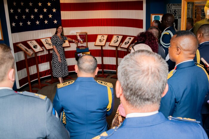 Melissa Sims presents information about exhibits to International Honor Roll guests in the Enlisted Heritage Hall at the Maxwell Air Force Base Gunter Annex, Alabama, April 10, 2026.