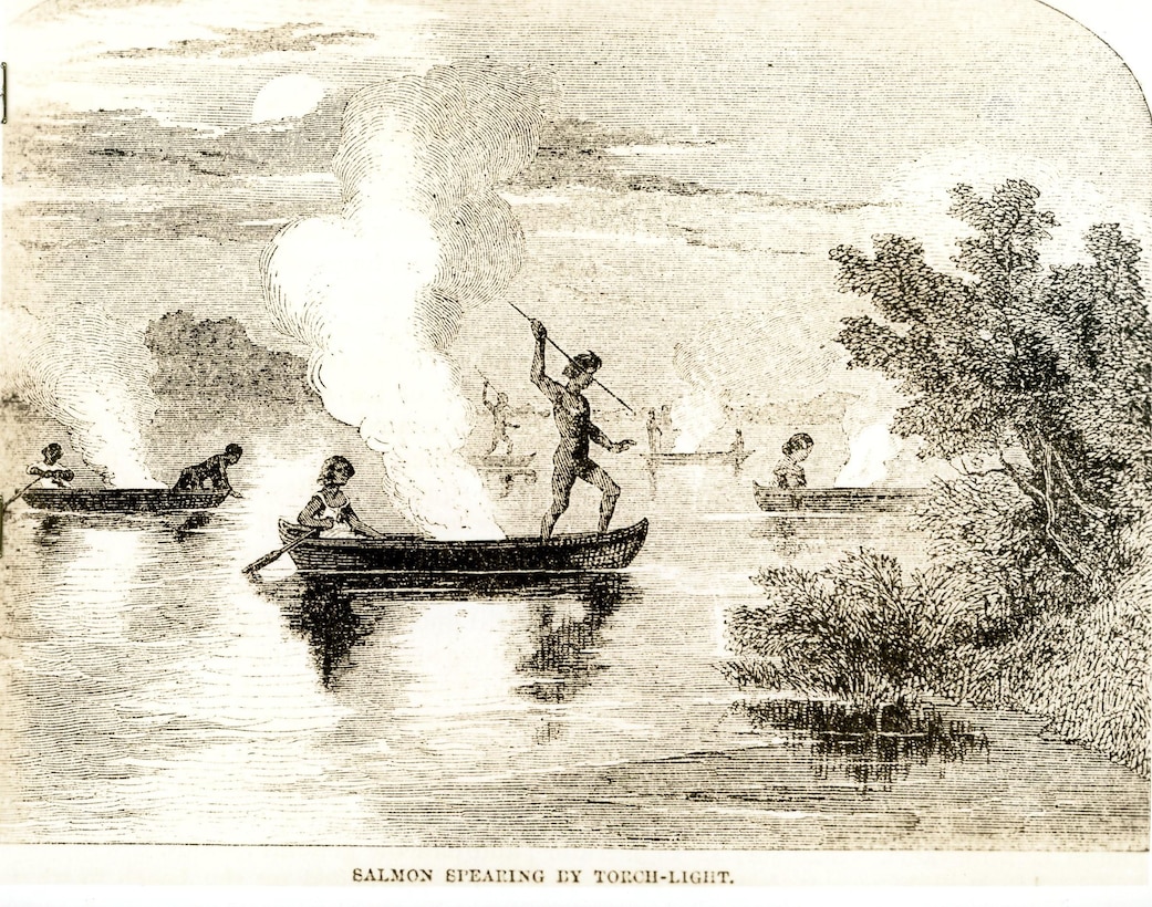 Image of people in canoes on a body of water approaching the shoreline.