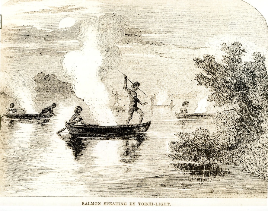Image of people in canoes on a body of water approaching the shoreline.