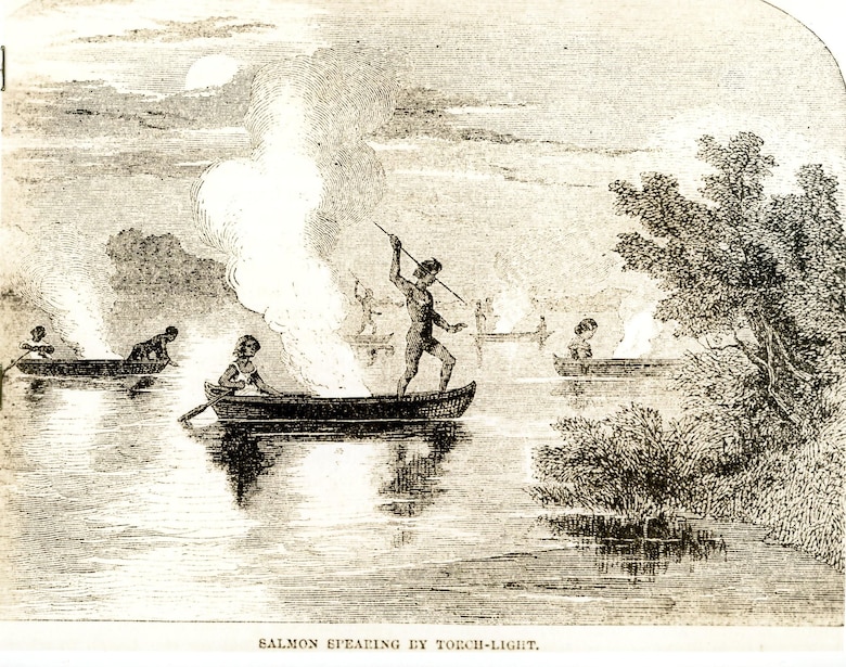 Image of people in canoes on a body of water approaching the shoreline.