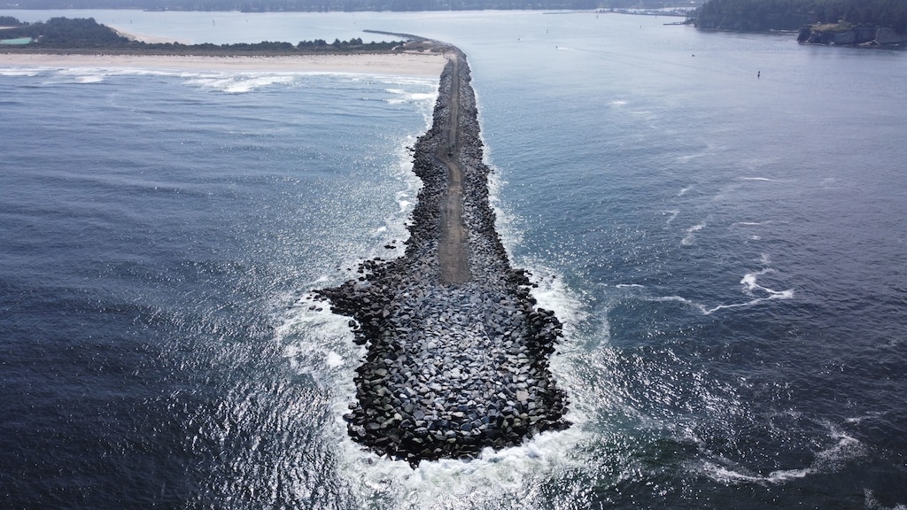 Image of a jetty protruding out from the coast line into the ocean.