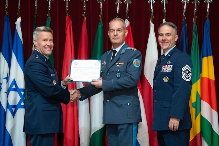 U. S. Air Force Lt. Gen. Daniel H. Tulley, Air University commander and president, and Chief Master Sergeant Raun M. Howell, AU command chief, induct Bulgarian Air Chief Maj. Gen. Nikolay Rusev Rusev into the 2026 International Honor Roll at Maxwell Air Force Base, Alabama, Apr. 10, 2026.