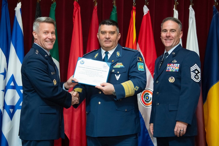 U. S. Air Force Lt. Gen. Daniel H. Tulley, Air University commander and president, and Chief Master Sergeant Raun M. Howell, AU command chief, induct Chief of the Romanian Air Force Staff Lt. Gen. Leonard-Gabriel Baraboi into the 2026 International Honor Roll at Maxwell Air Force Base, Alabama, Apr. 10, 2026.
