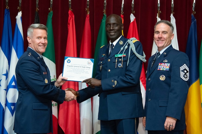 U. S. Air Force Lt. Gen. Daniel H. Tulley, Air University commander and president, and Chief Master Sergeant Raun M. Howell, AU command chief, induct Chief of Staff of the Senegalese Air Force Brig. Gen. El Hadji Niang into the 2026 International Honor Roll at Maxwell Air Force Base, Alabama, Apr. 10, 2026.