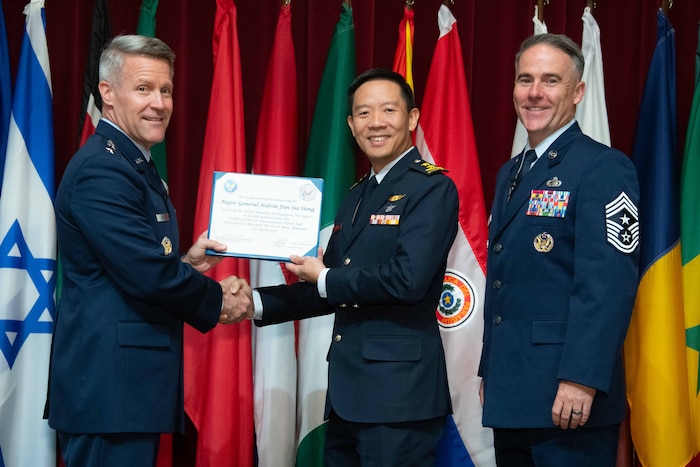 U. S. Air Force Lt. Gen. Daniel H. Tulley, Air University commander and president, and Chief Master Sergeant Raun M. Howell, AU command chief, induct Chief of Air Force, Republic of Singapore Air Force Maj Gen Kelvin Fan into the 2026 International Honor Roll at Maxwell Air Force Base, Alabama, Apr. 10, 2026.