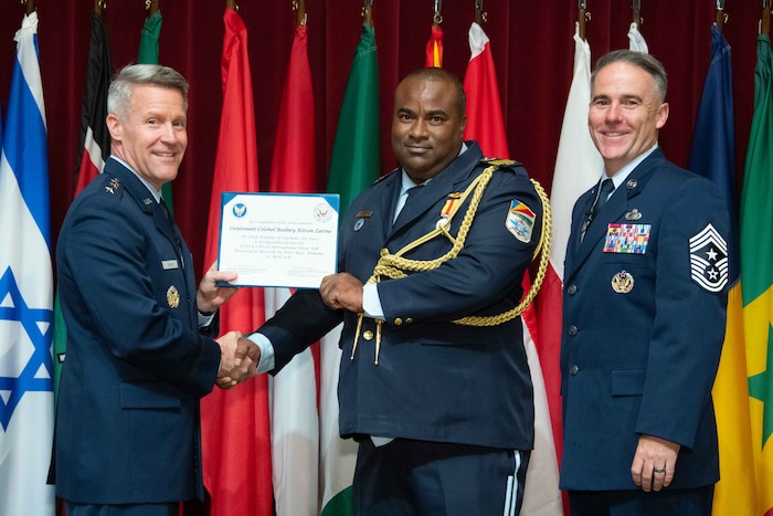U. S. Air Force Lt. Gen. Daniel H. Tulley, Air University commander and president, and Chief Master Sergeant Raun M. Howell, AU command chief, induct Republic of Seychelles Air Force Air Chief Lt. Col. Rodney Kitson Zarine into the 2026 International Honor Roll at Maxwell Air Force Base, Alabama, Apr. 10, 2026.
