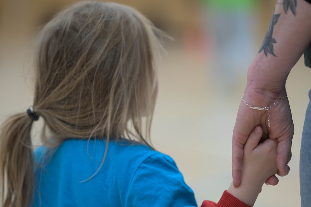 A child holds an adults hand.