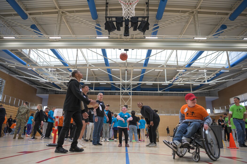 A group of people play basketball.