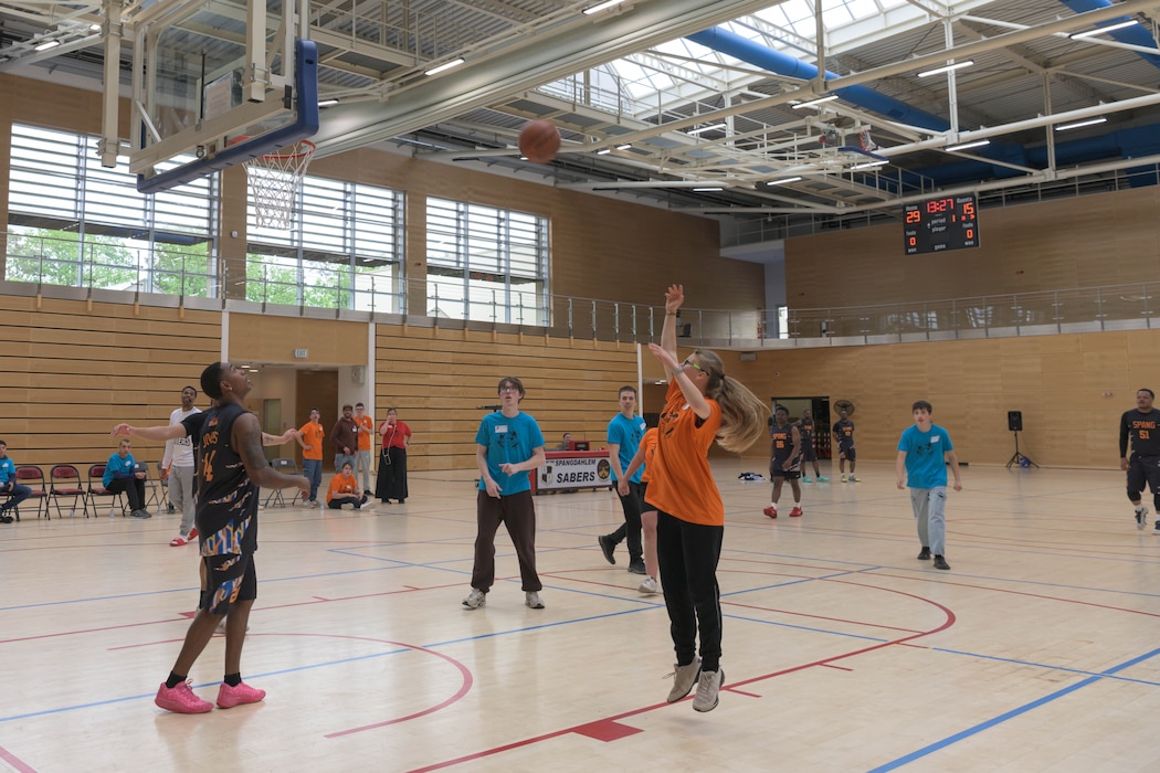 A person shoots a basketball into a hoop.