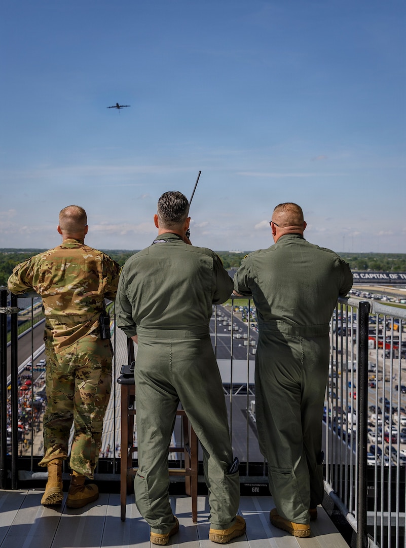 Indiana Army National Guard Col. Scott Oden, U.S. Air Force Capt. Nate Padgett and Capt. Cory Beck watch as a plane from Grissom Air Force Base arrives over Indianapolis Motor Speedway for a planned flyover at the Grand Prix in Speedway, Indiana, May 9, 2026.