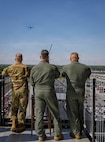 Indiana Army National Guard Col. Scott Oden, U.S. Air Force Capt. Nate Padgett and Capt. Cory Beck watch as a plane from Grissom Air Force Base arrives over Indianapolis Motor Speedway for a planned flyover at the Grand Prix in Speedway, Indiana, May 9, 2026.