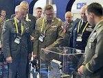 (From left) Swiss Armed Forces Maj. Gen. Simon Müller, chief of Cyber Command; Polish Maj. Gen. Karol Molenda, commander of Polish Cyber Command; U.S. Air Force Brig. Gen. Jason Christman, Air National Guard assistant to the commander, Sixteenth Air Force; and Czech Republic Brig. Gen. Radek Haratek, commander of Cyber and Information Warfare Command, view an original Enigma machine at the Polish Cyber Command booth during Impact'26 in Poznan, Poland, May 13, 2026. The Enigma machine was an electro-mechanical rotor device used by Nazi Germany and famously cracked by Polish mathematicians. Strengthening alliances with international partners is critical to countering modern cyber threats and ensuring allied nations possess the tools to defend shared interests and deter aggression in the cyber domain. (U.S. Air Force photo by Rabia Coombs)