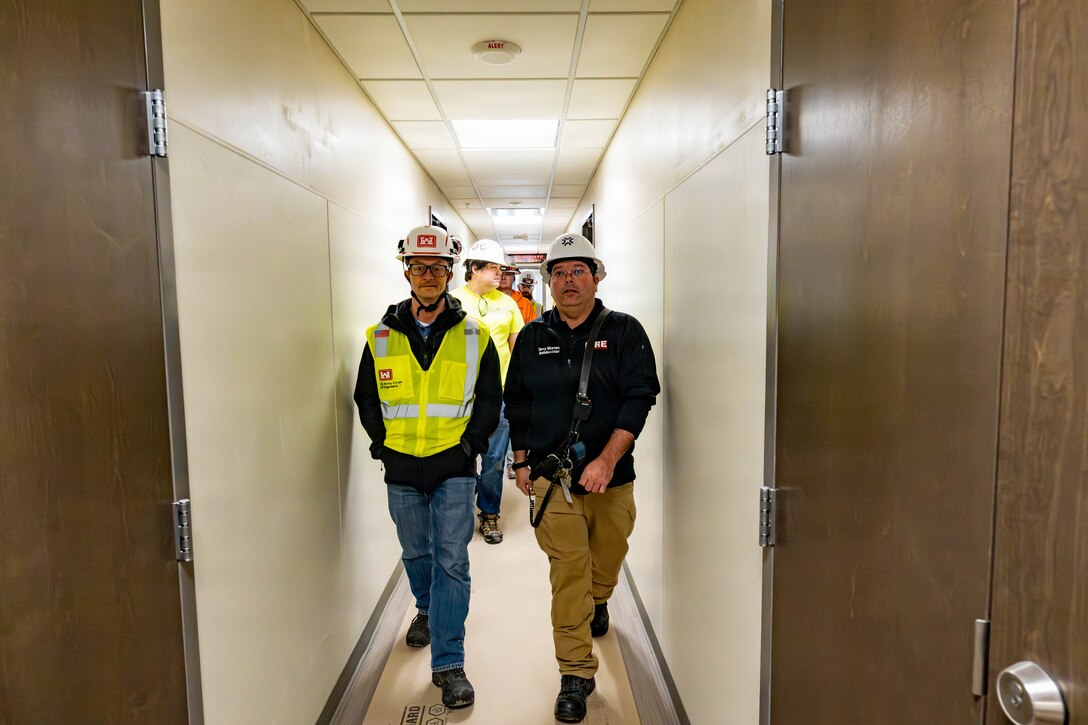 Fort Riley project engineer Clayton Plummer and a Battalion Chief with the Fort Riley Fire Department checking the newly installed fire alarm system in Building A on the complex.