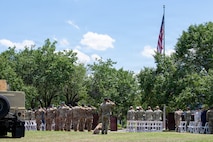 Service members and guests salute during the closing ceremony.