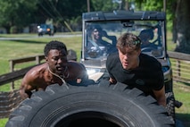 Service members lifting a tire during the Warrior Challenge.