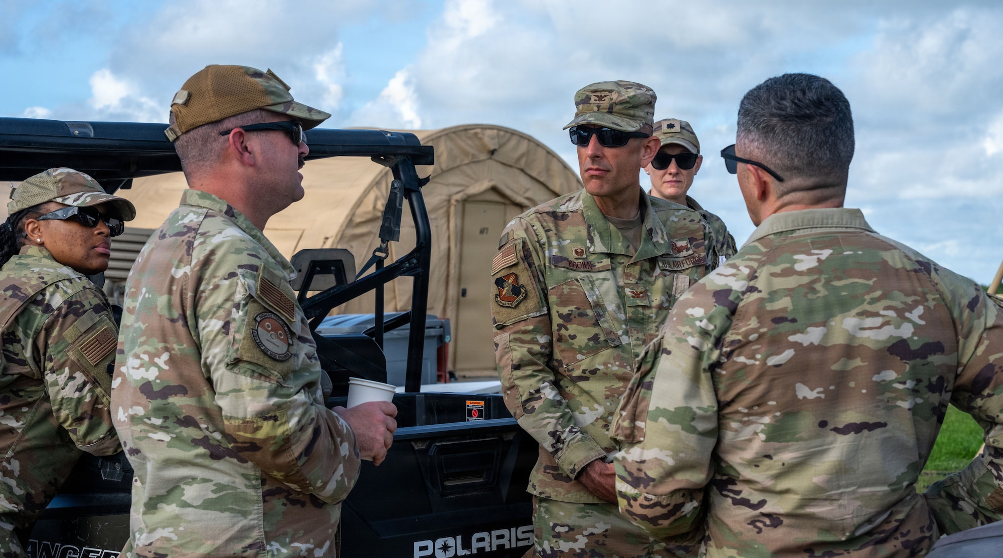 U.S. Air Force Col. Gabriel Brown, 406th Air Expeditionary Wing commander, center, listens to Airmen assigned to the 475th Expeditionary Air Base Squadron during a site visit at Manda Bay, Kenya, May 6, 2026. Brown and U.S. Air Force Chief Master Sgt. Jason Logan, 406th AEW command chief, met with Airmen and leaders to discuss operational priorities and mission support capabilities. (U.S. Air Force photo by Maj. Porter Maerz)