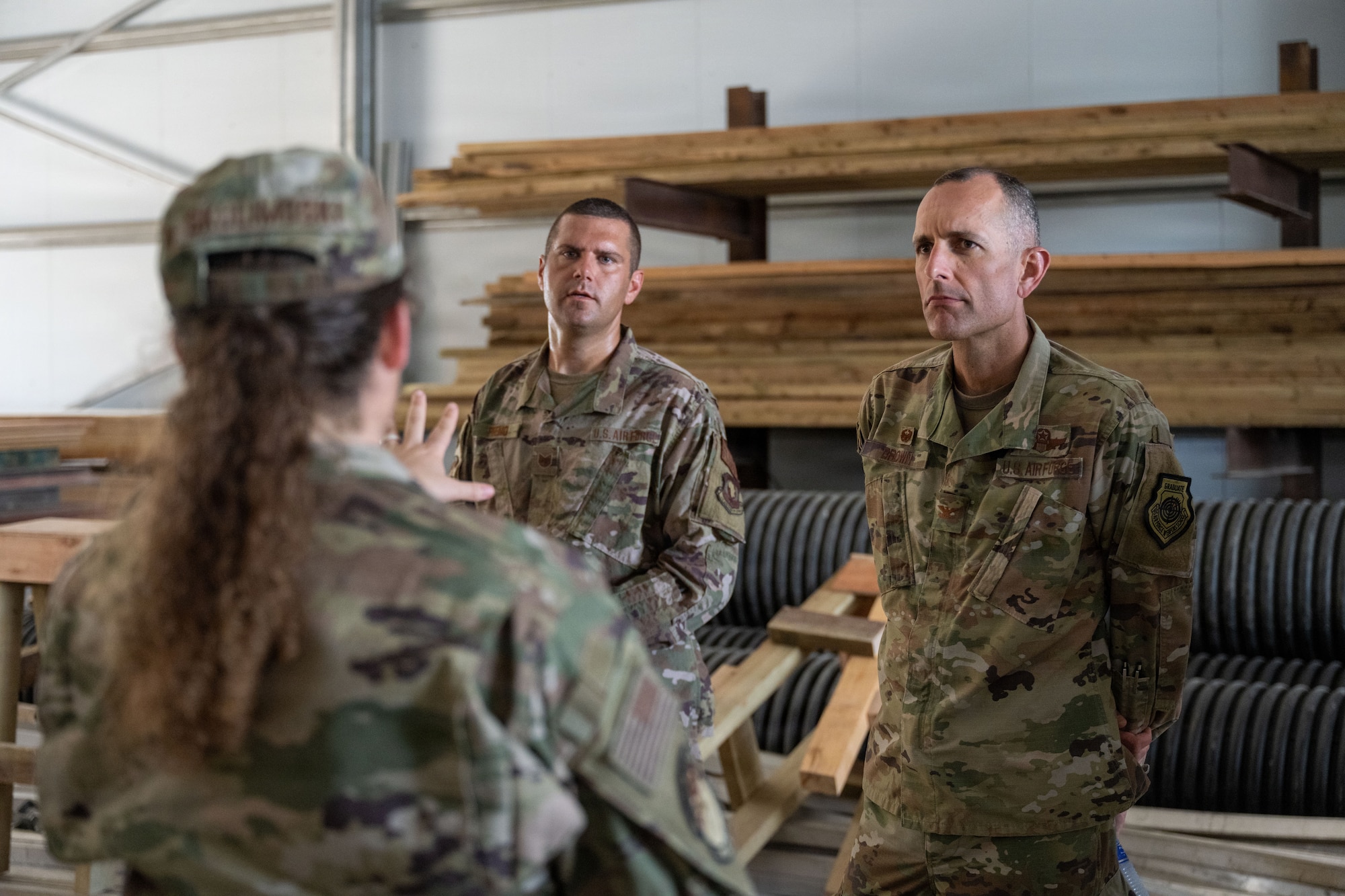 An Airman assigned to the 475th Expeditionary Air Base Squadron speaks to U.S. Air Force Col. Gabriel Brown, 406th Air Expeditionary Wing commander, right, and Chief Master Sgt. Jason Logan, 406th AEW command chief left, during a two-day immersion at Manda Bay, Kenya, May 6, 2026. Throughout the immersion, Brown and Logan toured multiple mission areas across Manda Bay Airfield, including the Department of State 10,000-foot runway development project site, vehicle maintenance operations, port facilities and civil engineer work sites. (U.S. Air Force photo by Maj. Porter Maerz)